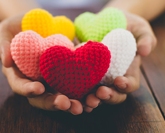 Mixed color yarn hearts in student hands